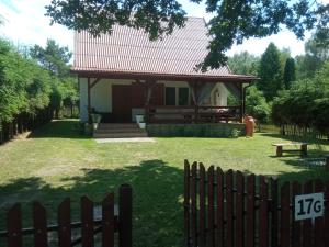 une petite maison avec un toit rouge dans une cour dans l'établissement Domek letniskowy "Pod dębem", à Urowo