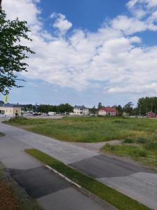 an empty road next to a field with houses at Willa Viktorin Vintti in Kristinestad