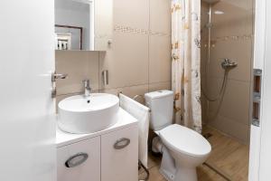 een witte badkamer met een toilet en een wastafel bij Confort Plus in Sibiu