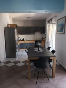 cocina con mesa, sillas y nevera en Sea View Apartment Sunrise Poljica & Blue Lagoon Rent A Boat, en Poljica