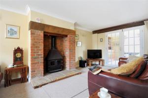 a living room with a brick fireplace and a couch at Moonfleet Cottage in Charmouth