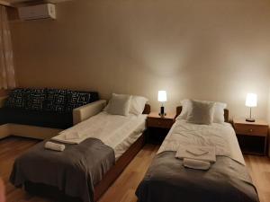 ホードメゼーヴァーシャールヘイにあるSunnyrise Apartmanのベッド2台、ランプ2つ(テーブル付)が備わる客室です。