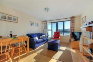 a living room with a blue couch and a table at 8 Driftwood in West Bay