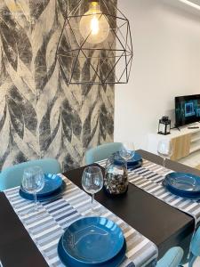 una mesa de comedor con platos azules y copas de vino en Romeo 207 en Oviedo