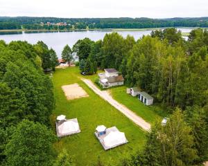 une vue aérienne sur un groupe de tentes et un lac dans l'établissement Mazurskie Chatki, à Mrągowo