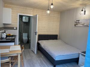 een slaapkamer met een bed, een bureau en een keuken bij Morena in Jarosławiec