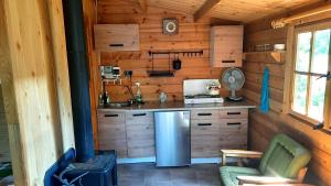 a kitchen in a log cabin with a refrigerator at Domek nad jeziorem Gowidlińskim in Podiazy