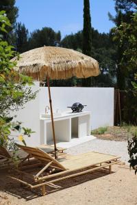 une table et des chaises avec un banc et un parasol dans l'établissement l'Amarantine, à La Ciotat