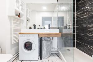 a bathroom with a washer and dryer under a sink at Design 3 bedrooms appartment, near Champs Elysees in Nanterre +9 photos
