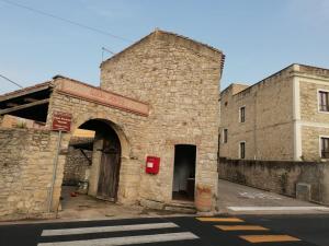 un viejo edificio de piedra con un letrero rojo. en Domus de Jara - Casa Montis en Baradili