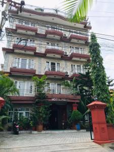 a hotel building with a lot of plants in front of it at Hotel Point Pokhara in Pokhara