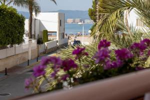 balkon z fioletowymi kwiatami i plażą w obiekcie CHALET VILLA Los HIPOCAMPOS w mieście Cullera