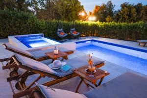 a pool with tables and chairs next to a swimming pool at Villa Pino with Pool, Sauna & Jacuzzi in Petrcane +151 photos