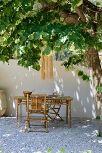 un tavolo in legno e una panca sotto un albero di l'Amarantine a La Ciotat