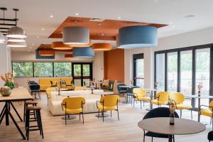 ein Restaurant mit gelben Stühlen, Tischen und Fenstern in der Unterkunft Belstay Roma Aurelia in Rom