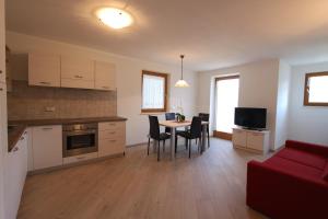 a kitchen and living room with a table and chairs at Varesco Appartamenti in Carano