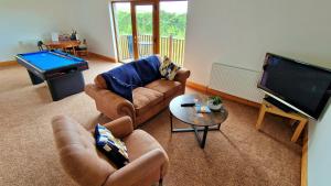 a living room with couches and a flat screen tv at Acarsaid B&B in Lybster