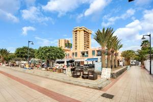 a city street with palm trees and a building at Nice studio Bart 50 meters from Playa Las Vistas in Arona