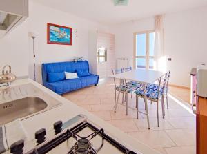 una cucina e un soggiorno con tavolo e divano blu di Grecale - By Ligooria a Boissano