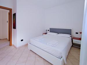 una camera bianca con letto bianco e pavimento piastrellato di Grecale - By Ligooria a Boissano