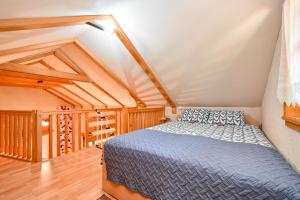 - une chambre mansardée avec un lit bleu dans l'établissement Kuca za odmor Hiza i Vila, à Krapina
