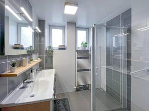 łazienka z przeszkloną kabiną prysznicową i umywalką w obiekcie Chez Minouche w mieście La Bresse +14 zdjęć