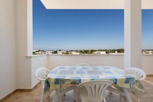 a dining room with a table and white chairs at Casa vacanza Mare Blu in Torre Lapillo