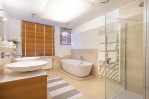 ein Bad mit einer Badewanne, einem Waschbecken und einer Dusche in der Unterkunft Haus Castell in Oberstdorf