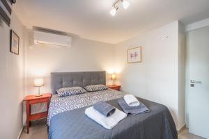 een slaapkamer met een bed met handdoeken erop bij Glyfada's Cosy Apartments in Athene