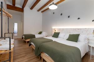 a bedroom with two beds with green and white sheets at Casa del Patriarca in Valencia
