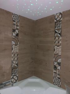 y baño con ducha, paredes de madera y azulejos. en Villa Iiulia, en Fiumefreddo di Sicilia