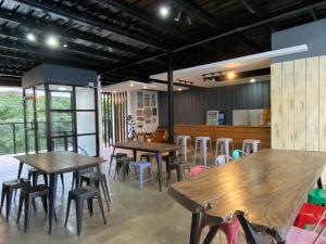 ein Restaurant mit Holztischen und -stühlen in einem Raum in der Unterkunft Bakawan Hostel in Coron