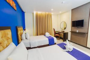 a hotel room with two beds and a television at Parkside Star Hotel Jayapura in Jayapura