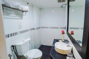 ein Badezimmer mit einem weißen WC und einem Waschbecken in der Unterkunft Parkside Star Hotel Jayapura in Jayapura