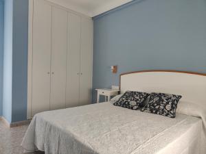 sypialnia z białym łóżkiem i dwiema poduszkami w obiekcie CHALET VILLA Los HIPOCAMPOS w mieście Cullera