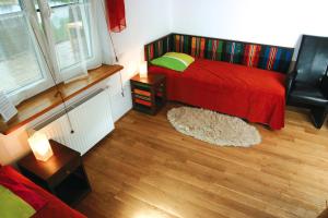 a bedroom with a bed with a red comforter at Bumerang Jolanta Foks in Chlebów