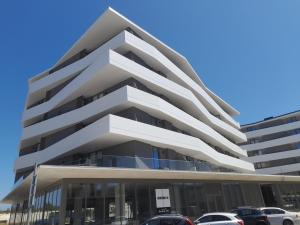 a tall building with cars parked in front of it at White Design Apartment in Aveiro