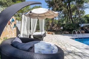 ein großer Korbstuhl neben einem Pool mit Sonnenschirm in der Unterkunft Villa Sole in Lecce