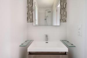 a white bathroom with a sink and a mirror at Maison moderne pour 4 personnes a Saint-Gildas-de-Rhuys in Saint-Gildas-de-Rhuys