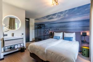 a hotel room with a bed and a mirror at Dormio Wijnhotel Valkenburg in Valkenburg