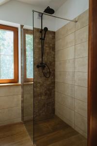 a shower with a glass door in a bathroom at Frešer Farm Accommodation 