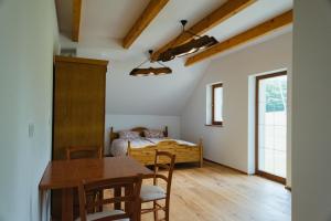 a bedroom with a bed and a table and chairs at Frešer Farm Accommodation in Zgornje Prebukovje