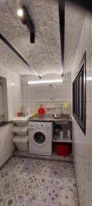 uma cozinha com uma máquina de lavar roupa e um lavatório em Au coquelicot : gîte cosy pour 8 pers. avec jardin em Ath