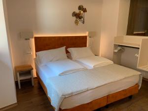 a bed with white sheets and pillows in a room at Albergo Ristorante Montebaldo in Limone sul Garda