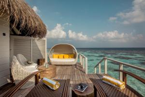 a deck with a chair and a bed on the ocean at Drift Thelu Veliga Retreat in Dhangethi