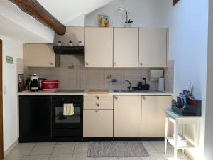 una cucina con mobili bianchi e un lavandino di Ascona, Casa Collegio - im Zentrum, am See Lago Maggiore ad Ascona Altre 8 foto