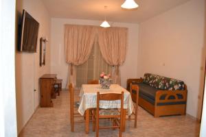 uma sala de estar com uma mesa e um sofá em Xenios Zeus Hotel em Cárpatos