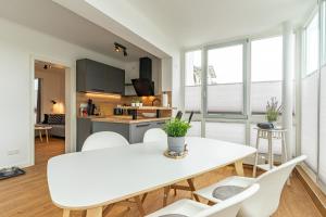 Una cocina y una sala de estar con una mesa y sillas blancas. en Appartement Nr 7 im Sonnenbad, en Sassnitz