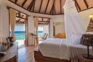 Drift Thelu Veliga Retreat في دانجيثي: غرفة نوم مع سرير وإطلالة على المحيط