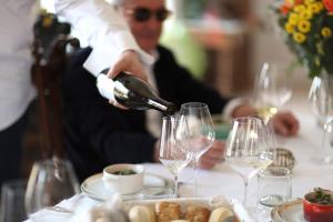 un homme versant du vin dans des verres sur une table dans l'établissement Domaine Gille, à Comblanchien 18 autres photos